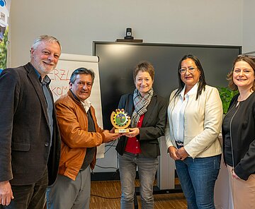 Die zwei Delegierten aus Ecuador überreichen ein Gastgeschenk an Bürgermeisterin Bettina Lisbach.
